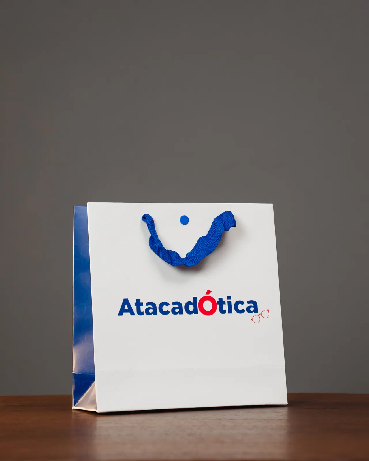 Sacola de papel branca personalizada Atacadótica com alça de gorgurão azul
